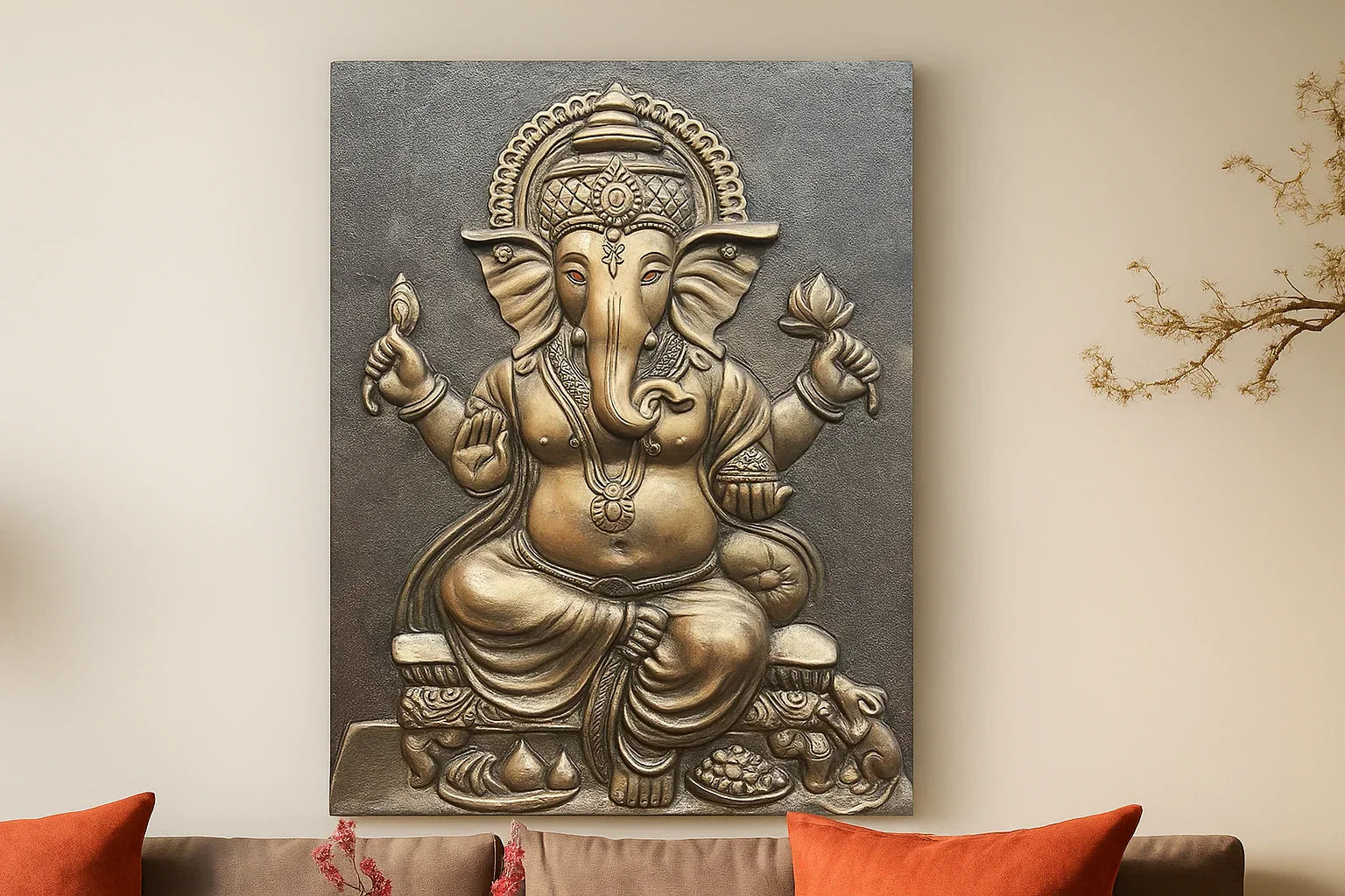 Elegant wall mural art of Lord Ganesha in a golden bronze finish, depicting the deity seated with traditional ornaments and symbolic objects, mounted on a beige wall above a sofa with orange cushions