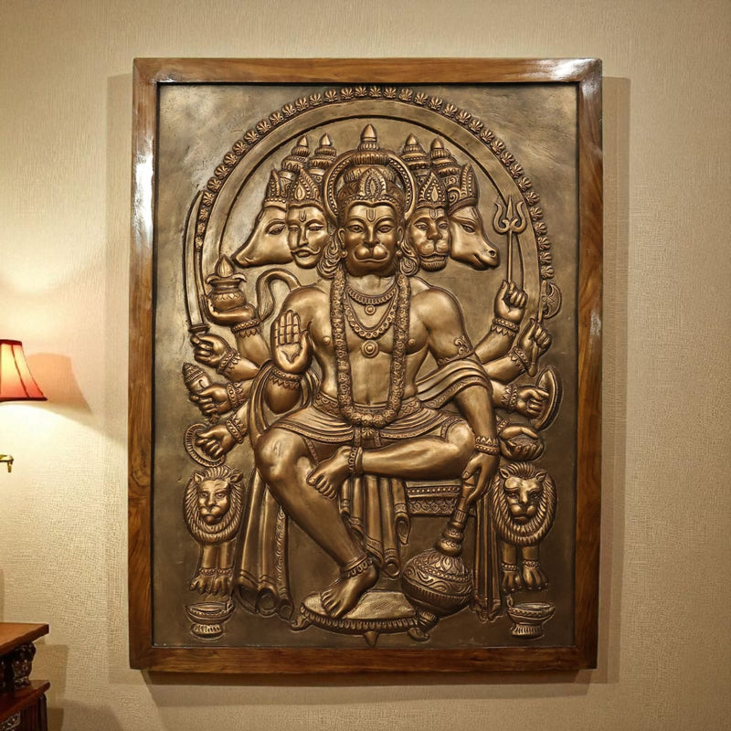 Panchmukhi Hanuman sculpture in intricate bronze relief, showcasing Lord Hanuman with five faces symbolizing various deities, detailed jewelry, and multiple arms holding sacred objects.