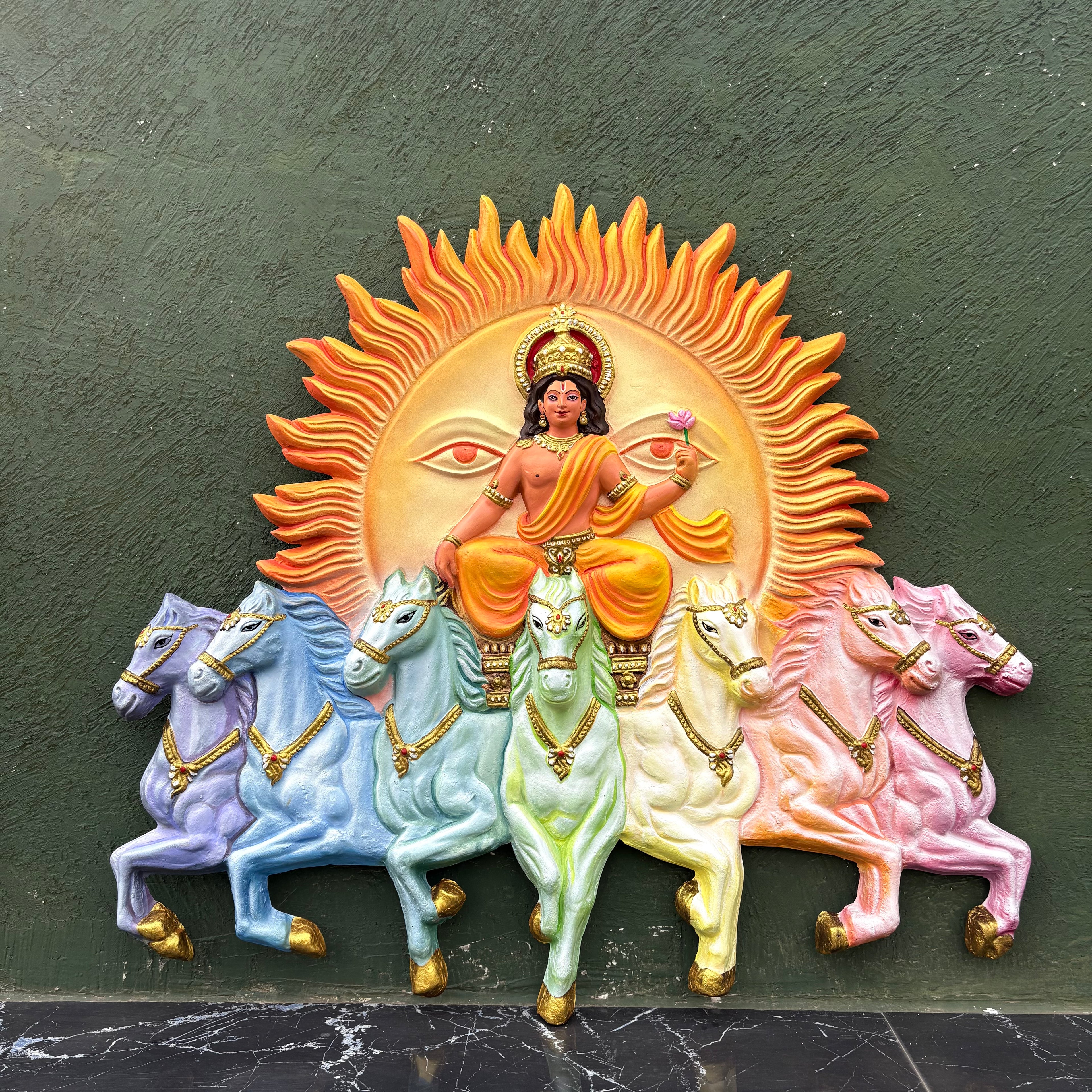 Handcrafted Surya Narayana wall art depicting the divine Sun God riding a chariot drawn by seven horses in vibgyor  and size is 4x3.5 feet.