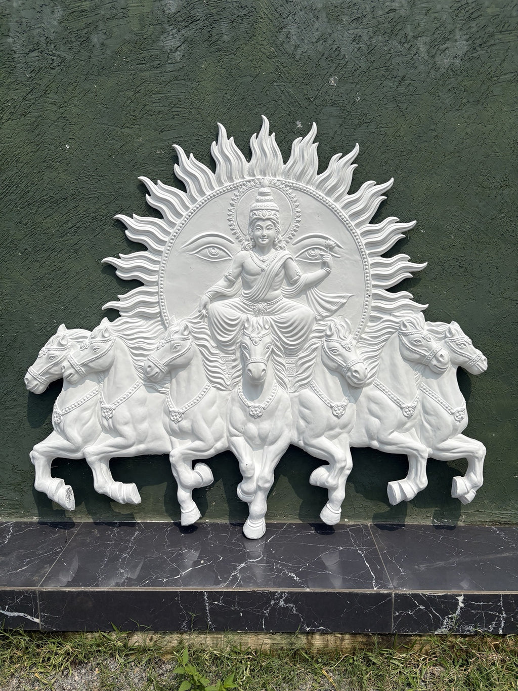 Detailed texture of Lord Surya Narayana wall sculpture showing layered relief work and fine ornamental detailing.