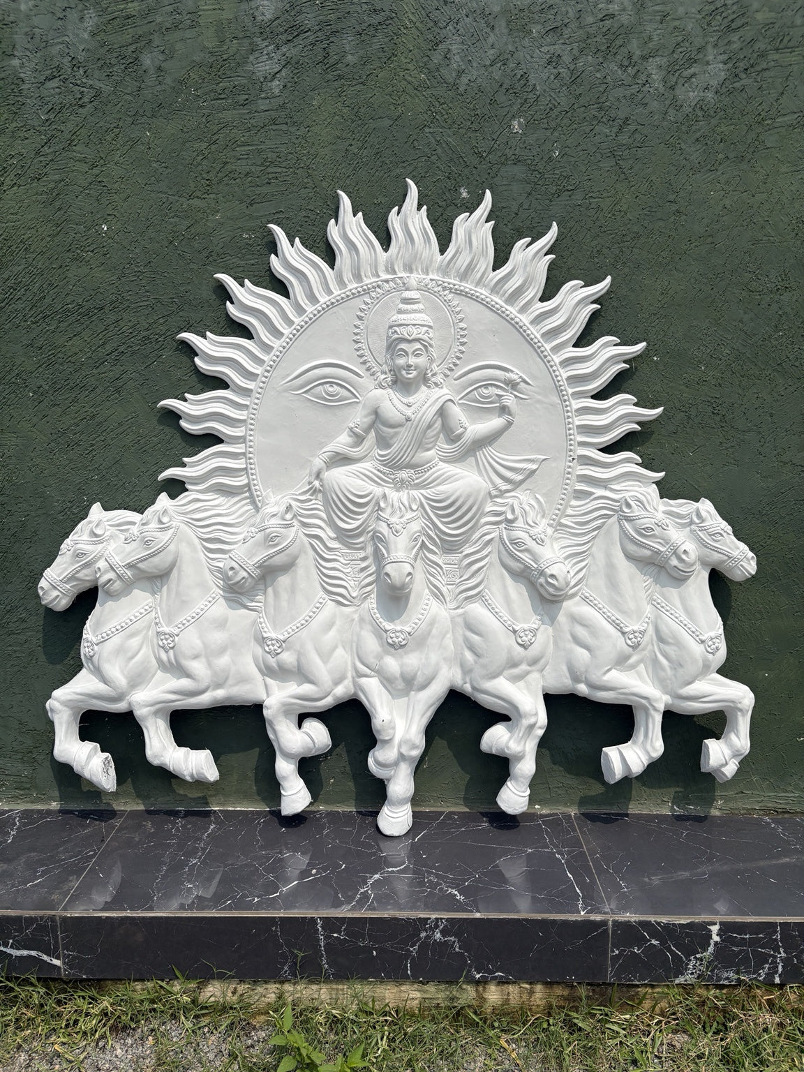Detailed texture of Lord Surya Narayana wall sculpture showing layered relief work and fine ornamental detailing.
