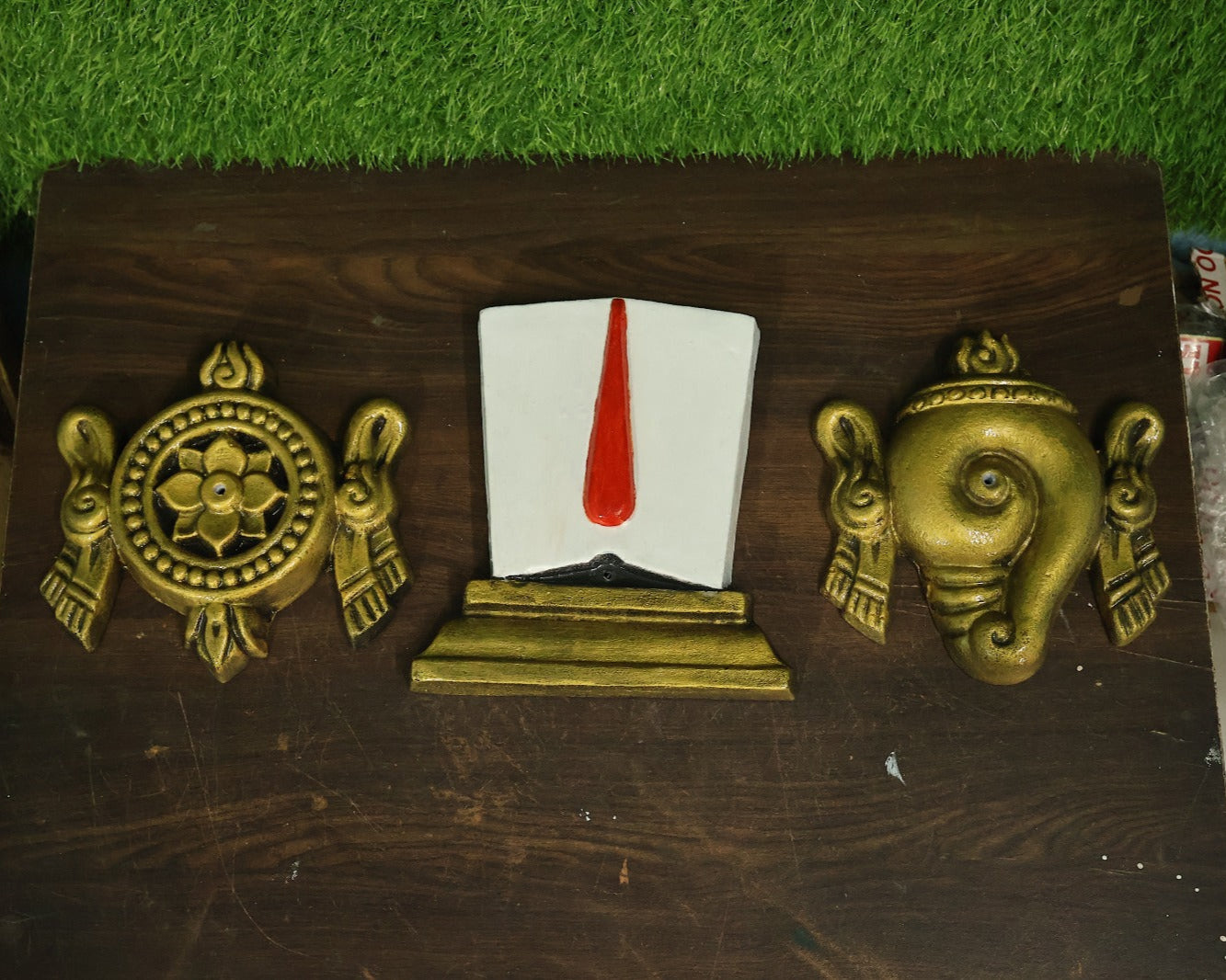 Fiber Mural of Shankha Namam Chakra set installed above a wooden panel